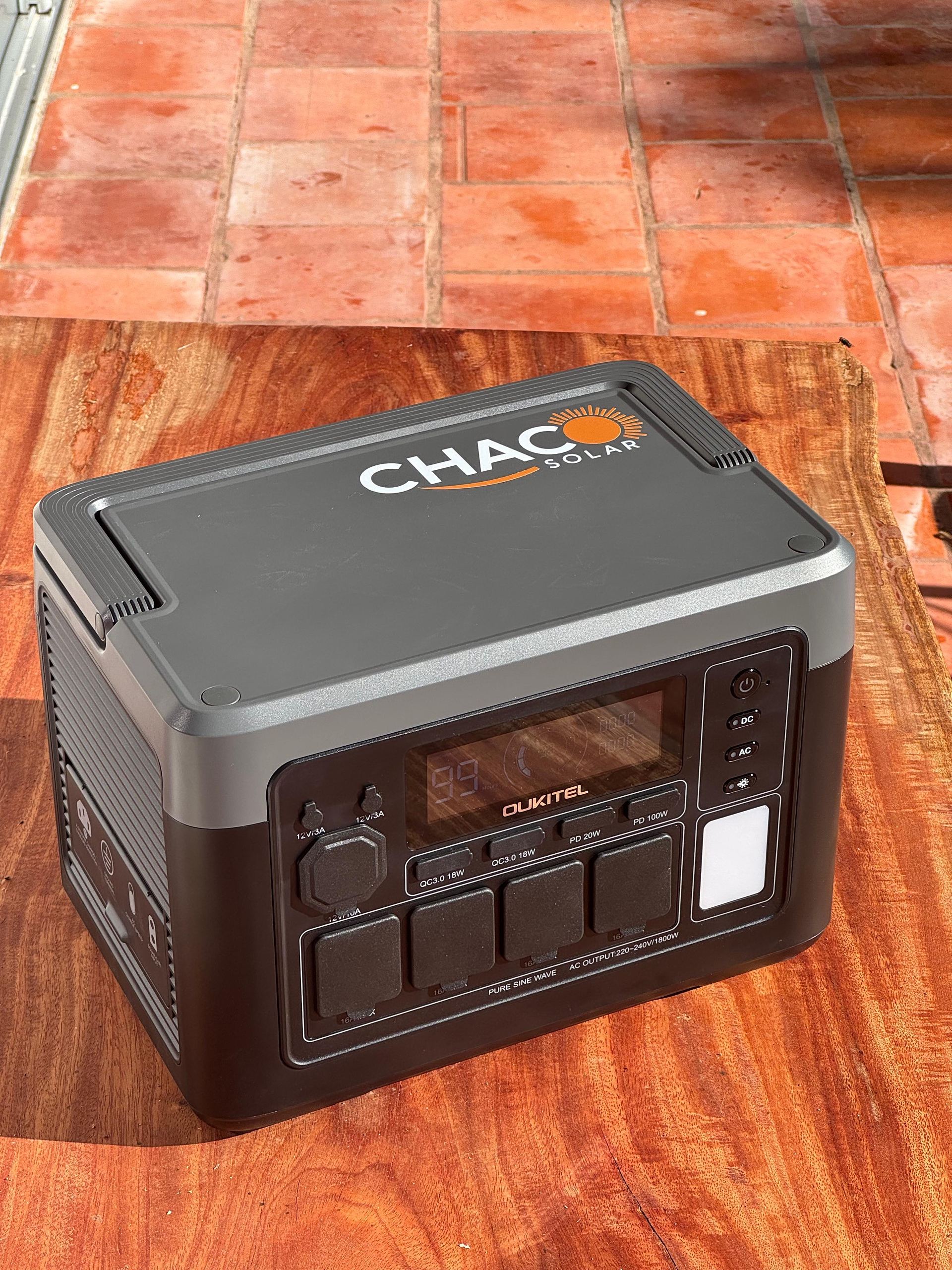 Estación de energía Oukitel con el logo de Chaco Solar sobre una mesa de madera