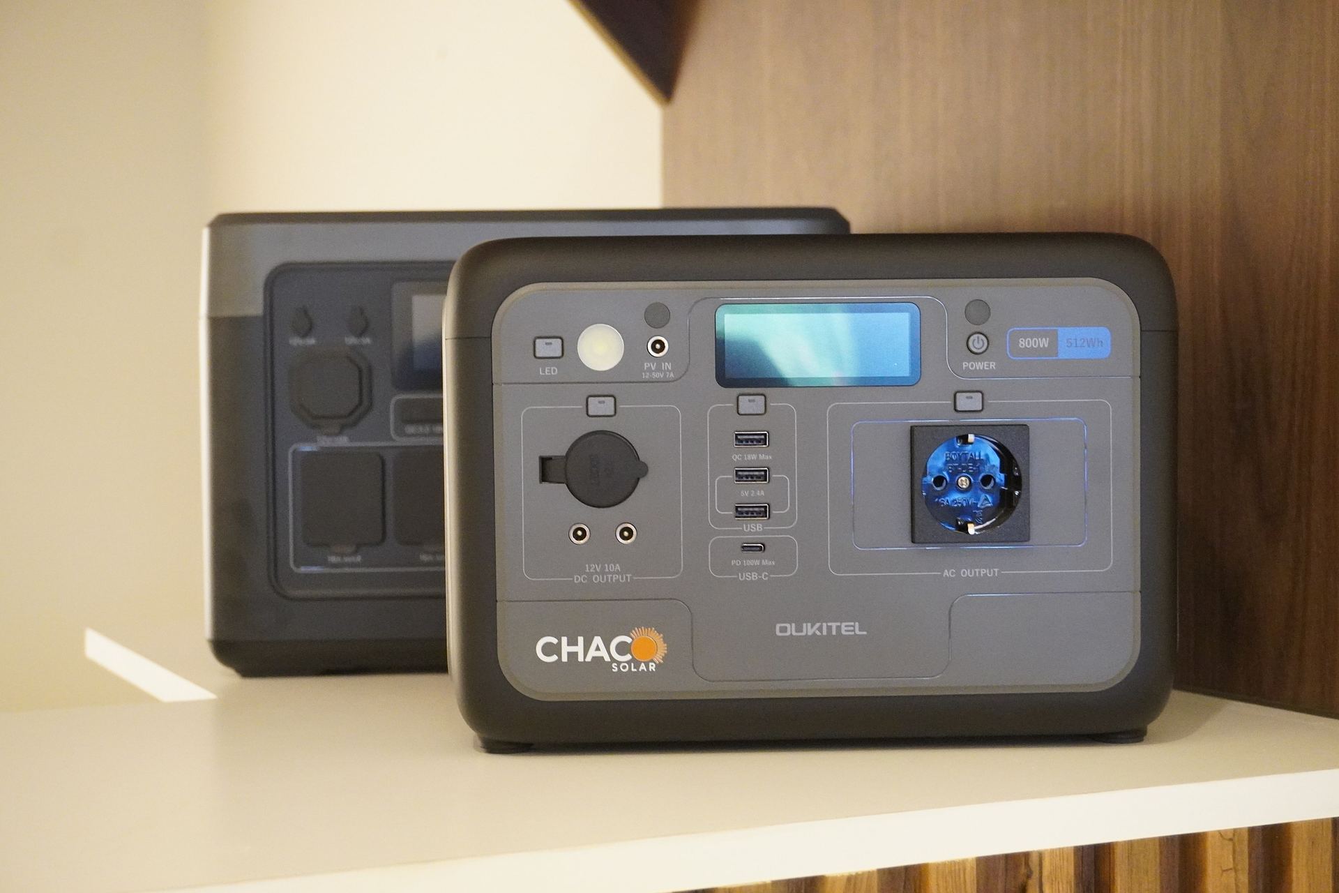 Dos estaciones de energía Oukitel con el logo de Chaco Solar en un estante del showroom