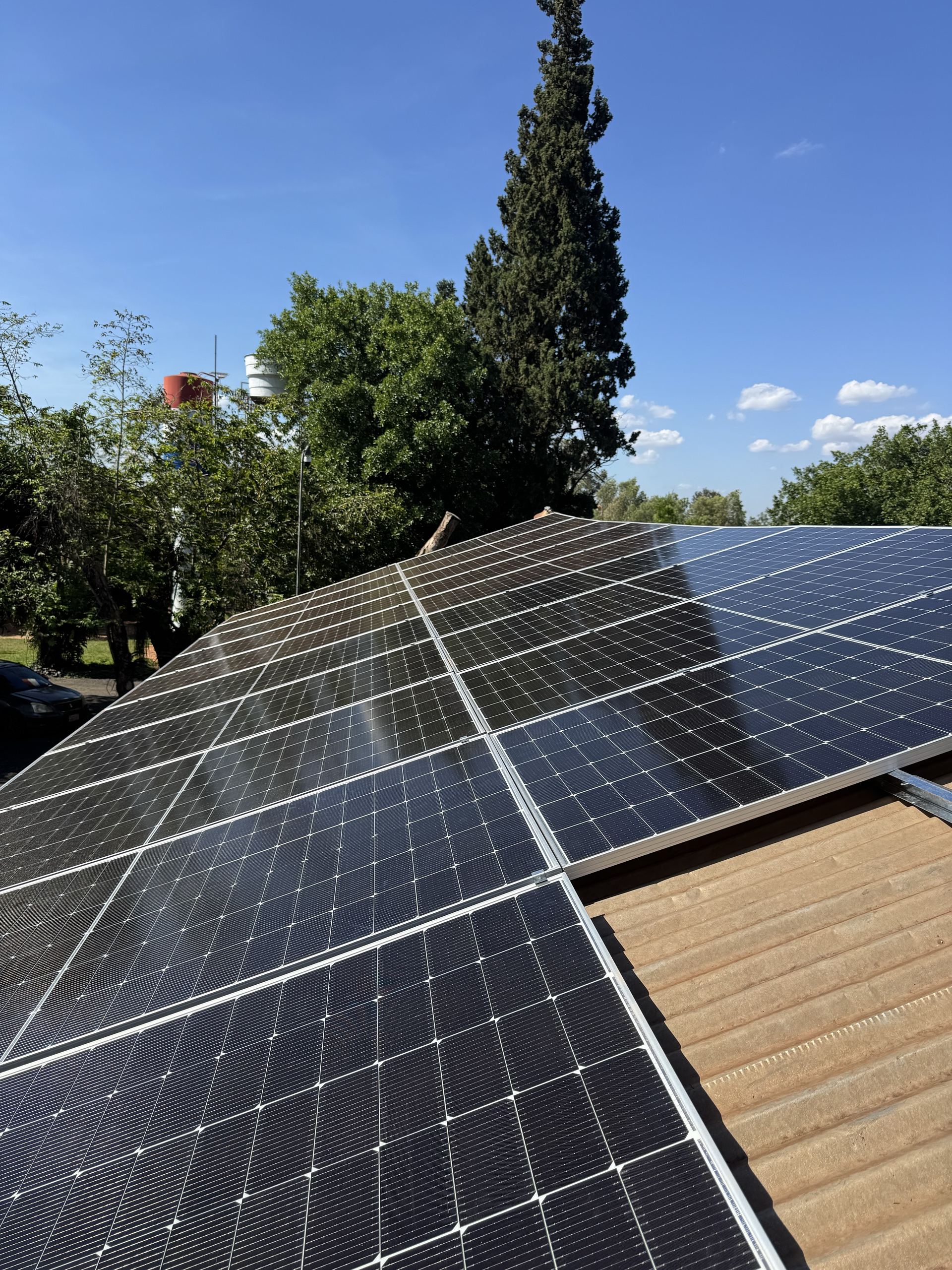 Módulos solares no telhado de uma casa sob um céu azul